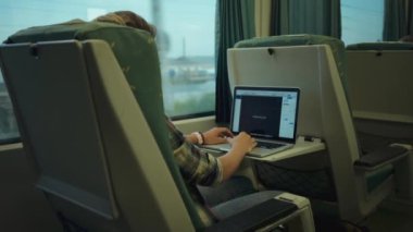 Young woman work on project on laptop in train