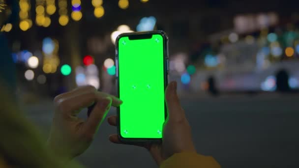 Person hold smartphone vertical at night city — Stok video