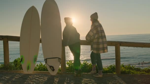 Duas mulheres surfistas conversam sobre ondas perto da praia — Vídeo de Stock