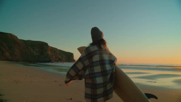 Kvinnlig surfare kvinna i casual outfit promenad på stranden — Stockvideo