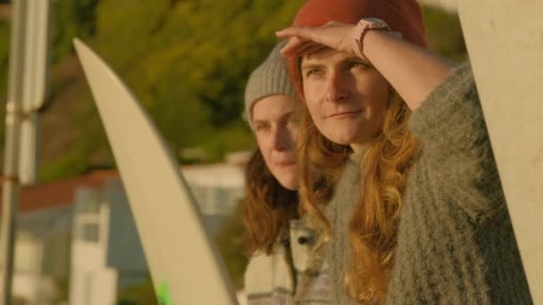 Duas mulheres surfistas conversam sobre ondas perto da praia — Vídeo de Stock