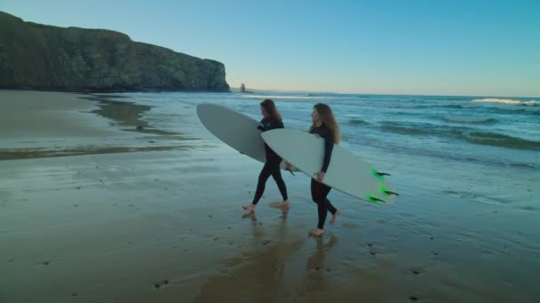 Dwie przyjaciółki surferki spędzają czas na epickiej plaży — Wideo stockowe