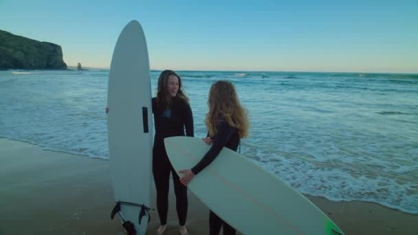 Две подруги-серферши зависают на эпическом пляже — стоковое видео