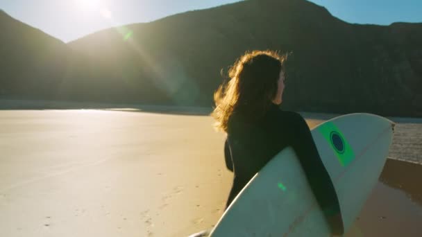 Authentic shot of surfer run on sunrise beach — Stockvideo