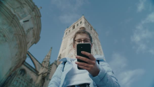 Mujer utilizar el teléfono inteligente en la calle de la ciudad a texto — Vídeo de stock