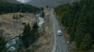 Orman yolundaki karavanın sinematik drone görüntüleri.