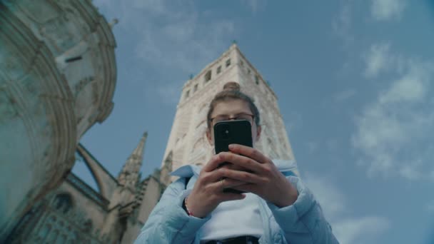 Mujer utilizar el teléfono inteligente en la calle de la ciudad a texto — Vídeo de stock