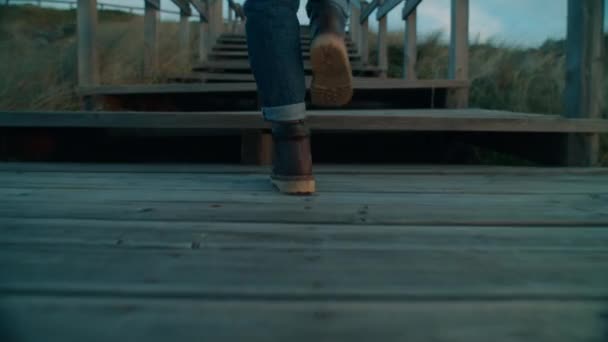 Camera follows woman in hiking boots on boardwalk — Stock Video