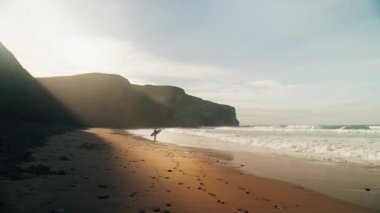 Sörfçülerin güneşlendiği sinematik okyanus plajı