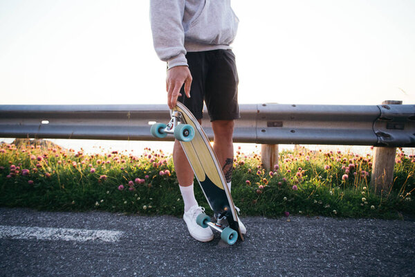 Young hipster man carry longboard at sunset Royalty Free Stock Photos