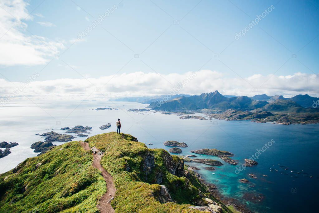 Man stand on top of epic mountain in Lofoten