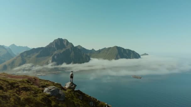 Epic drone shot of man hiker stand on lofoten top — Stock Video