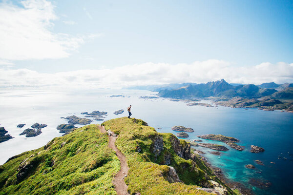Man stand on top of epic mountain in Lofoten Stock Photo
