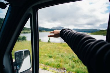 Kadın elini arabanın camından dışarı uzat, seyahat titreşimleri...