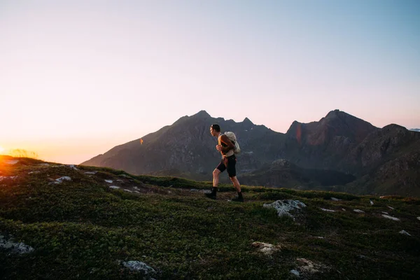 Lonely young man hiking on mountain at sunset — Stock Photo, Image