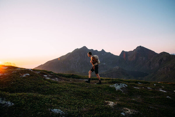Lonely young man hiking on mountain at sunset Stock Image