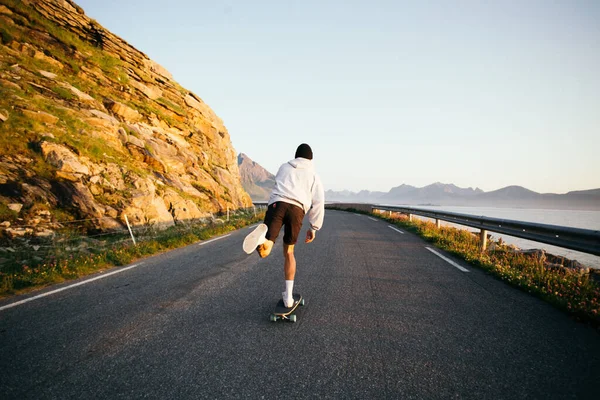 Millennial hipster man rida longboard på episk väg — Stockfoto