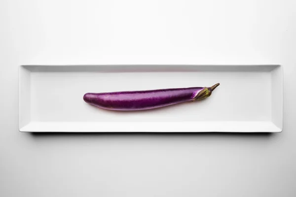 Long eggplant isolated on blank white plate — Stock Photo, Image
