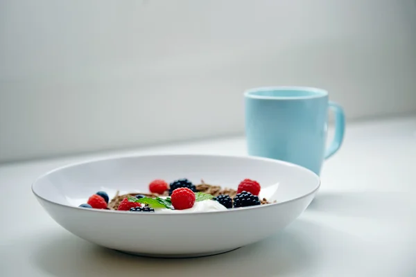 Muesli voor het ontbijt met mix van bessen en munt laat op tafel — Stockfoto