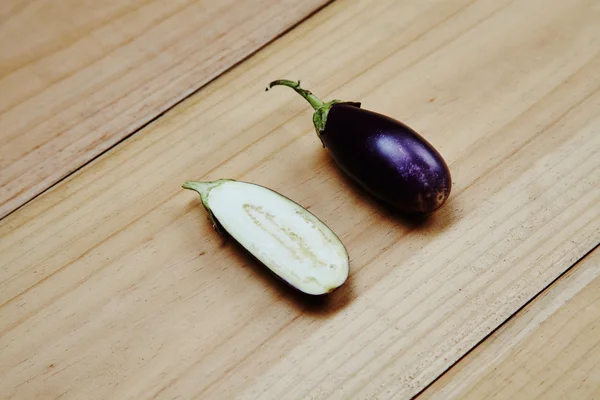 Splitted eggplant on wood in perspective — Stock Photo, Image
