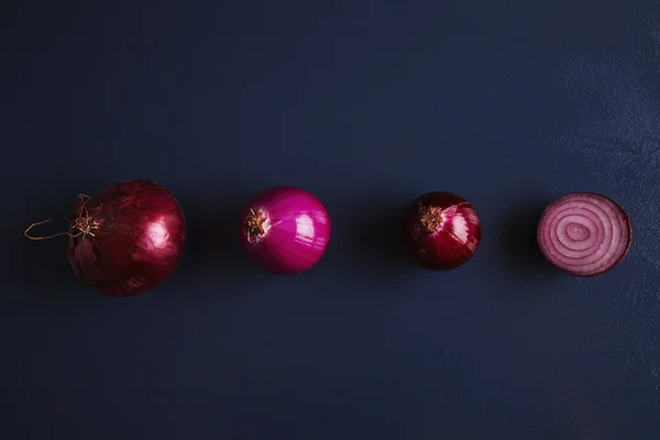 Cuatro cebollas rojas varias: normal, pelada, parcialmente pelada y dividida — Foto de Stock