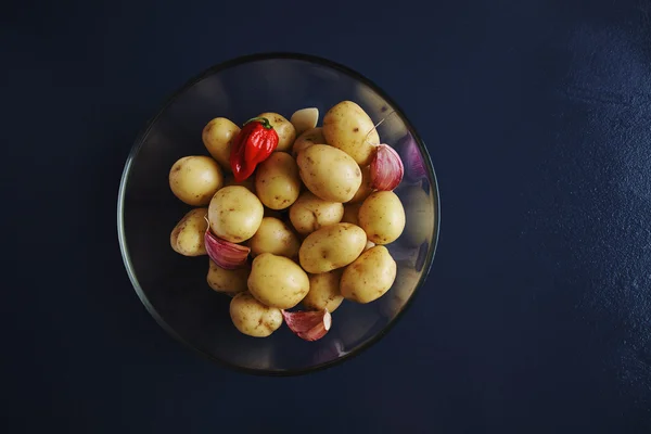 Batatas de bebê com alho e pimenta vermelha quente em tigela transparente — Fotografia de Stock