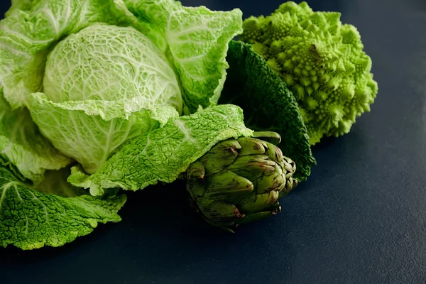 Chou blanc, brocoli romanesco et artichaut sur table bleue — Photo