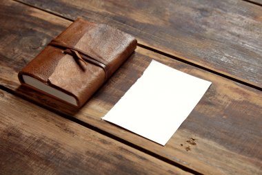 notbook ve bir kenara gelen ahşap bir masa üzerinde bir kağıdın