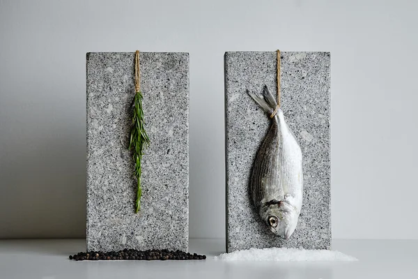 Риба Дорадо і розмарин представлені на кам'яних цеглинах — стокове фото
