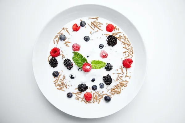 Muesli met melk en bessen bij het ontbijt — Stockfoto