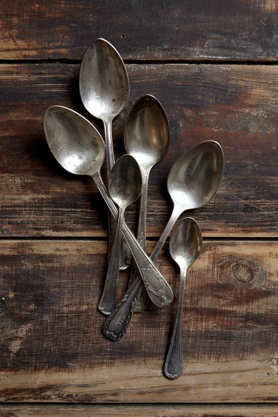 Different vintage spoons on a wooden table — Stock Photo, Image
