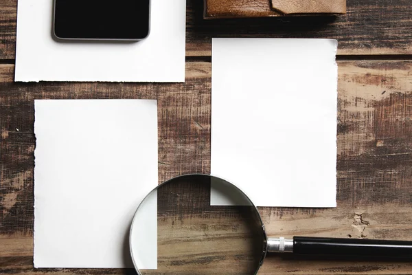 Hojas de papel con teléfono móvil sobre una mesa de madera — Foto de Stock