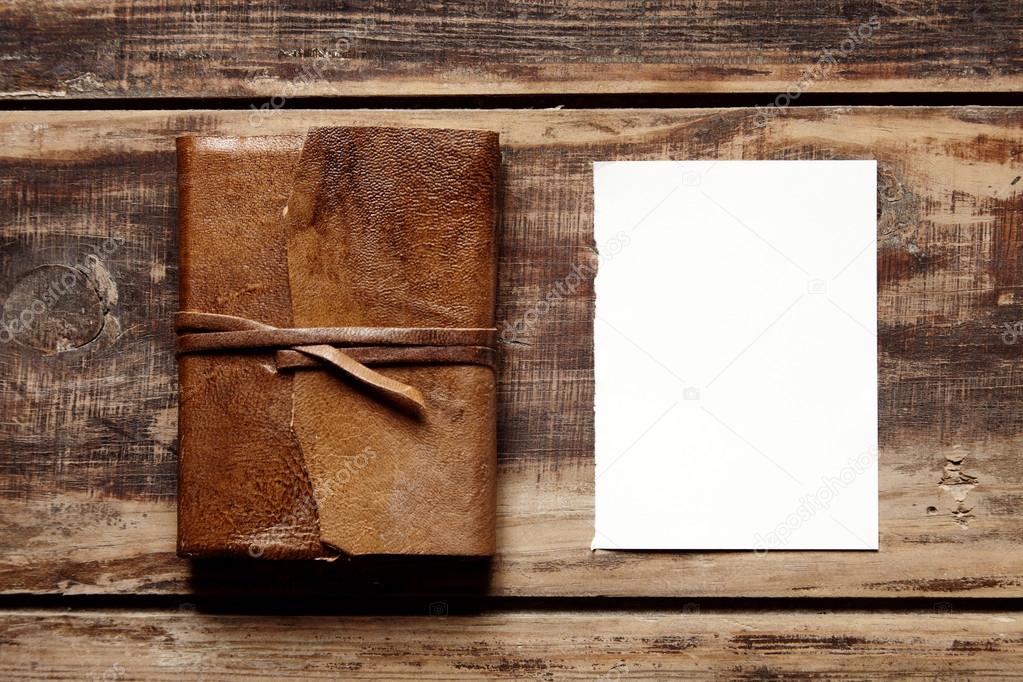 open notebook with leather cover on a wooden table