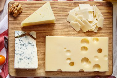 four cheeses closeup on wooden board clipart