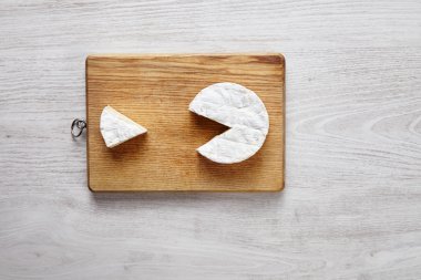 Camembert pacman style isolated on chopping board top view white