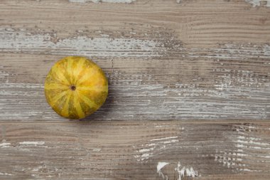 Striped small pumpkin alone on grunge table top view isolated