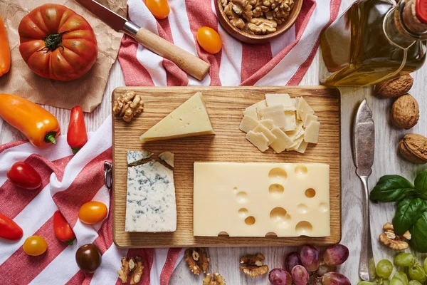 Prato de queijo com legumes e fornecedores vista superior — Fotografia de Stock