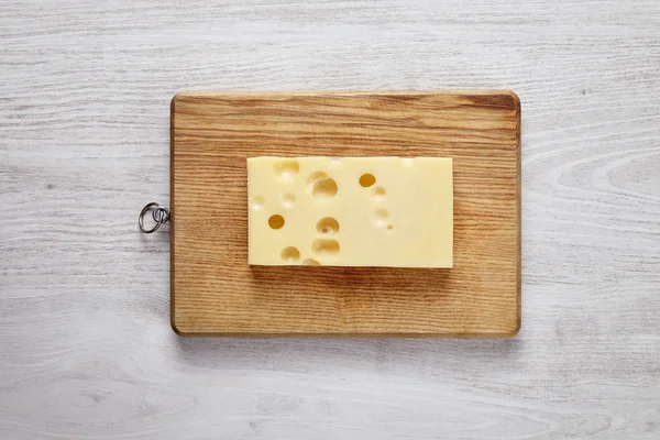 Queijo emmental isolado em tábua de madeira — Fotografia de Stock