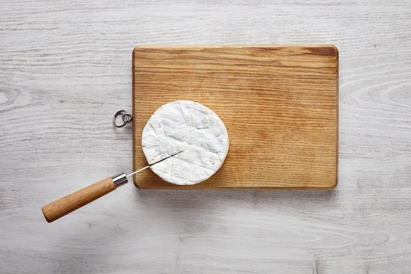 Cutting camembert top view knife brushed white table wooden boar — Zdjęcie stockowe