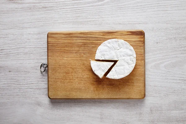 Splitted camembert cheese on chopping plate — Stock Photo, Image
