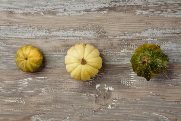 Two kinds of pumpkins and patison on grunge wooden table top vie — Stock Photo, Image