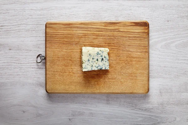 Um pedaço de queijo roquefort fresco em tábua de madeira — Fotografia de Stock