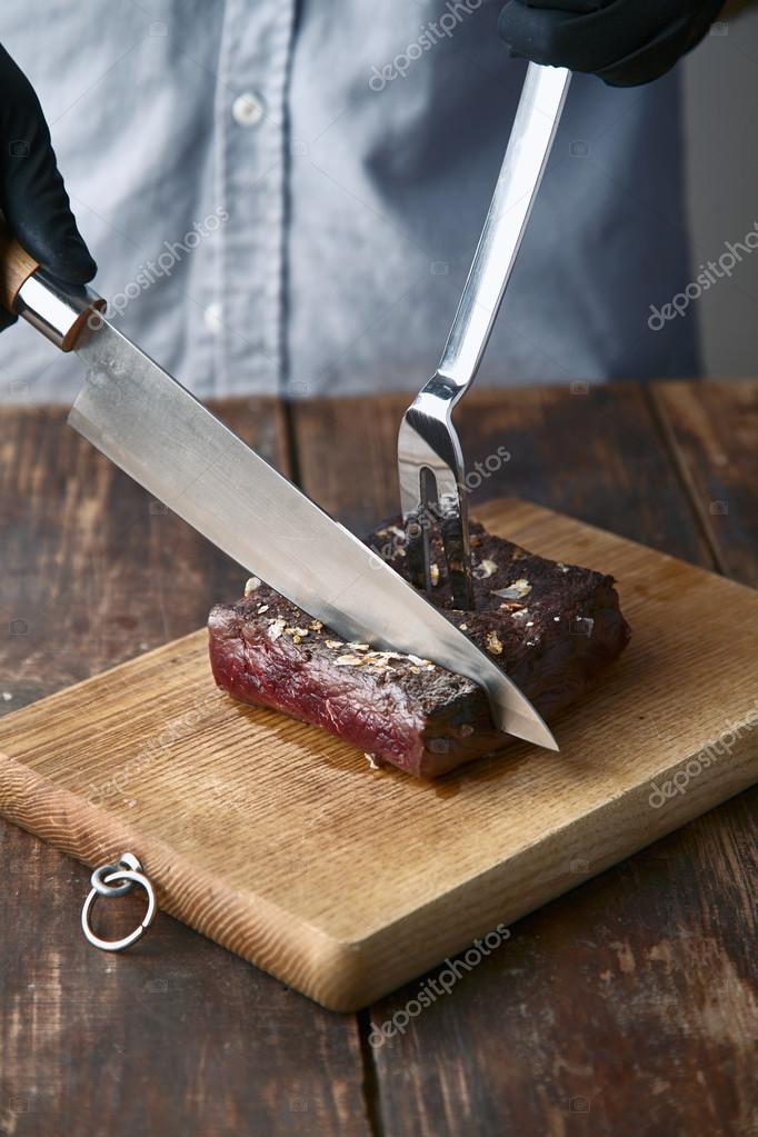 Hands cut medium rare cooked whale meat steak — Stock Photo © derepente