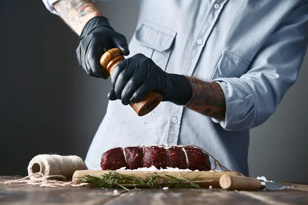 Мясник перец связал кусок мяса стейка, чтобы курить, крупным планом — стоковое фото