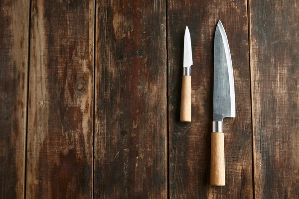 Dos viejos cuchillos cepillados grandes y pequeños sobre mesa de madera — Foto de Stock