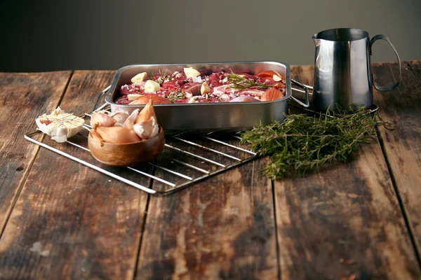 Carne na panela de aço com especiarias prontas para cozinhar na mesa de madeira — Fotografia de Stock