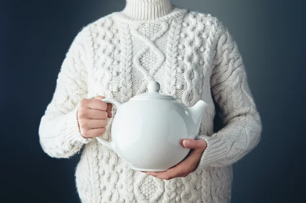 Tetera blanca grande con té en las manos en el aire — Foto de Stock