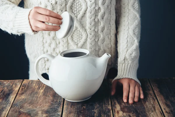 Femeie în pulover cald deține capac de ceainic alb mare în mâini — Fotografie, imagine de stoc