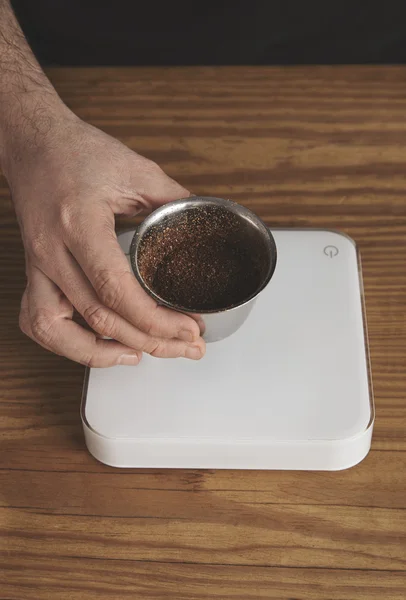 Mannenhand gewichten beker met de gemalen koffie — Stockfoto