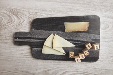 Top view cheese letters and marble board